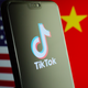 A phone with the TikTok logo in front of American and Chinese flags.